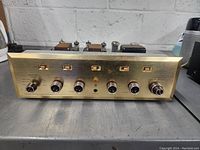 Front panel brass faceplate with five toggle switches, six speaker binding posts and headphone jack