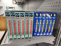 Side view of the two Starblazers series boxed sets of VHS tapes on a shelf showing all VHS tape spines numbered VII to XII in Series 2 and I to VI in Series 1.