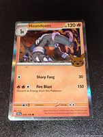 Close-up image of the Houndoom Pokémon foil card showing the artwork, stats, and moves.