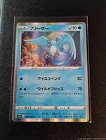 Close-up of the holo Articuno Pokémon card from the front showing card details and Japanese text under non-flash light.