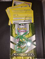 Rayquaza themed deck box with various Pokémon Trainer Item cards visible on top.
