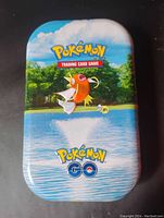 Photo of the collectible tin showing Magikarp jumping out of water with Pokemon Trading Card Game and Pokemon GO logos.
