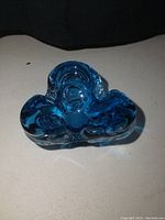Front view of the blue art glass dish showing its textured, rounded tripartite shape.