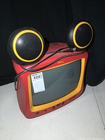 Front view of Disney Mickey Mouse CRT TV with black and yellow spherical speakers connected by wire on top.