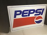 Full front view of the rectangular metal Pepsi sign showing the Pepsi logo in blue, red parallelogram, and logo circle on white background.