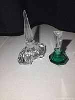 Photo of two glass perfume bottles together on a neutral background, showing size and shape difference