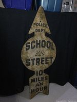 Full view of the vintage embossed metal arrow sign with Police Dept School Street and 10 miles an hour text.