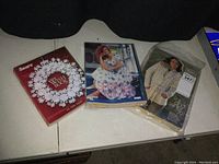 Three vintage Sears catalogs on a white surface including Fall and Winter 1979, Spring 1989, and 2010 Wish Book.