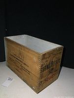 Front side of vintage wooden crate with finger joined corners showing CIL logo, SUBMAGEL 60%, weight information, and natural wood texture with knots.