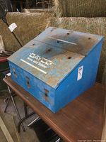 Full view of blue Dayco metal hose and tubing dispenser showing surface rust and the "Dayco Hose and Tubing" logo on top.