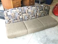 Photo of RV sofa showing patchwork fabric backrest and brown cushioned seat from above and side views.