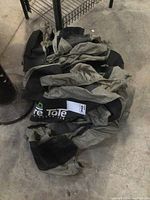 Photo of four tire covers folded on the ground showing fabric material and folded state.