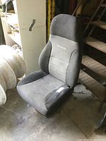 Heavy truck air seat with grey fabric upholstery, contoured shape, and National logo on backrest. Seat is dusty with light wear.