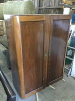 Front view of the two-section wardrobe cabinet placed together showing paneled wooden doors with ring pull handles.