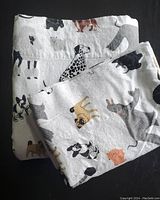 Folded 100% cotton flannel sheets and pillow shams featuring a dog breed print on a light background.