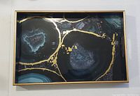 Full top view of the golden and agate patterned rectangular serving tray with gold frame and built-in handles.