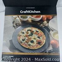 Box showing a cooked pizza on a 13 inch ceramic pizza stone and the Craft Kitchen brand.