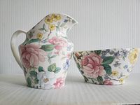 Side view showing the creamer and sugar bowl with floral designs and shape details