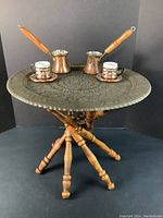 Full set on black background showing tray on wood stand holding coffee pots and cup sets