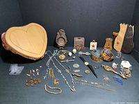 Overview of lot contents showing assorted jewelry, wooden box, pouch and small decor items