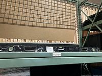 Photo showing the full length of the black Husky 4 ft level placed on a metal shelf.