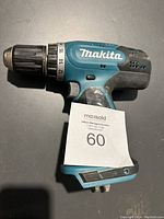 Left side view of Makita cordless drill showing model and grip area with Makita logo.