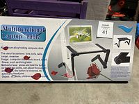 Photo of the product box showing a multifunctional laptop table with aluminum alloy construction, folding legs, and adjustable angle and height for versatile use.