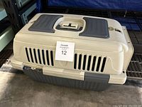 Side view of pet carrier showing ventilation slots and handle on top