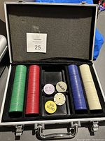 Open aluminum case showing poker chips in green, red, blue, white colors, plus dealer and blind buttons inside foam insert