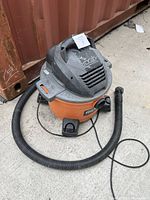 Full view of Ridgid shop vacuum including main unit and hose showing its overall condition and setup.