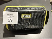 Front view showing Ryobi logo and speaker's mesh grill, note of dirt and wear visible