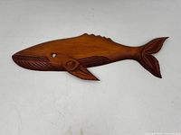 Full frontal view of carved wooden whale showing overall shape and carving details