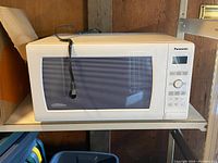 Front view of the Panasonic microwave showing the entire unit with power cord visible.