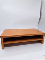 Front view showing the rectangular top surface and open shelf below for storage.