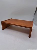 Full view of the teak veneer desk organizer showing rectangular shape with two side panels, medium-brown teak grain visible.