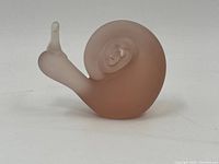 Front view of the frosted peachy-pink glass snail with clear glass antennae