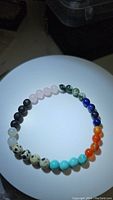 Full view of the bracelet showing the arrangement of beads of different colors and stones.