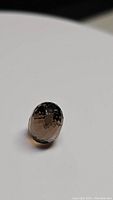 Single close-up image of the faceted smokey quartz gemstone showing its oval briolette cut and translucent smoky brown color.