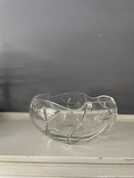 Clear, heavy glass bowl with angular design, free of chips or cracks, showing front and side views to illustrate condition and shape.