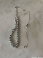 Silver-tone Swarovski necklace with round crystals laid flat to show chain length and design