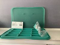 Teal Snack Bar mold with multiple rectangular compartments and its original packaging and beaters in plastic bag.