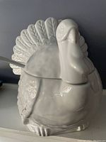 Front view of glossy white ceramic turkey tureen with lid