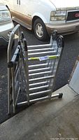 Folded 9-foot aluminum ladder showing wide base and joint mechanism