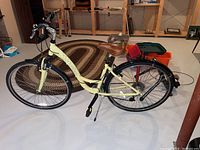 Full left-side view of cream-yellow Trek women's bicycle showing step-through frame, fenders, saddlle and kickstand