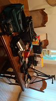 Overall display of cameras, camcorders, tripod, film boxes, camera bags, and accessories on a table
