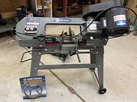 Full view of King Canada metal cutting bandsaw on stand with 64" blade and box