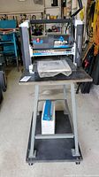 Front view of planer mounted on stand, manual on tabletop