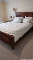 Full view of queen bed frame assembled with bedding and pillows