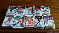 Multiple stacks of vintage NHL hockey cards featuring various teams and players.