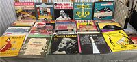 Wide view of over 50 vintage vinyl records showing variety of artists and Broadway themes, some orchestral and jazz titles visible.